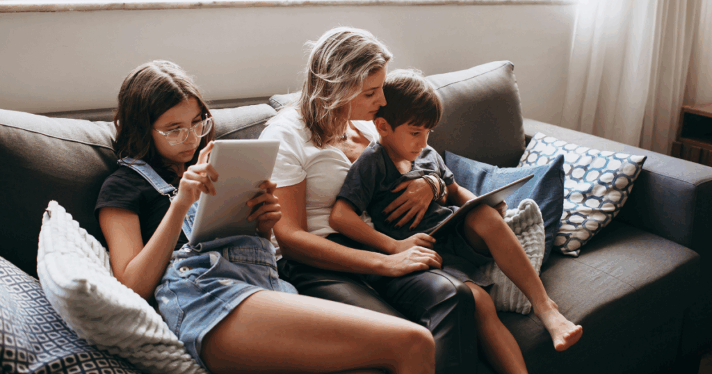 mamma che siede sul divano insieme ai suoi due bambini